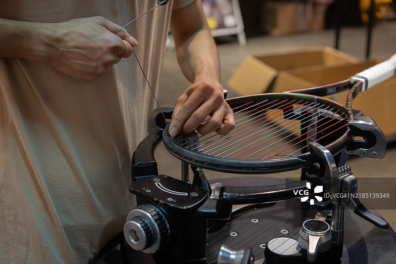网球线工的手在进行球拍穿线的特写镜头图片素材