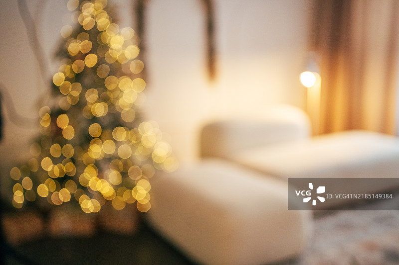 装饰有灯光的模糊圣诞树，背景是装饰温馨的客厅图片素材