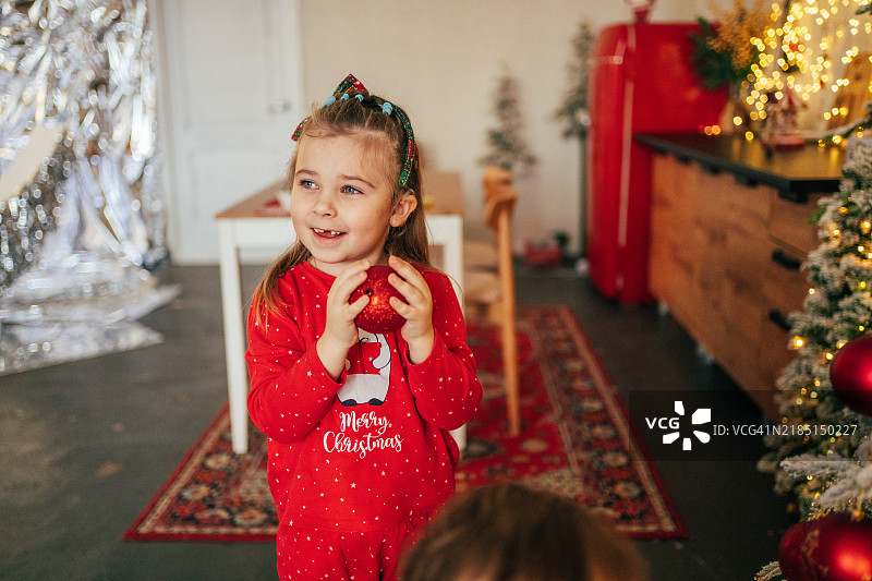 微笑的女孩佩戴着人工耳蜗在家中装饰圣诞树图片素材
