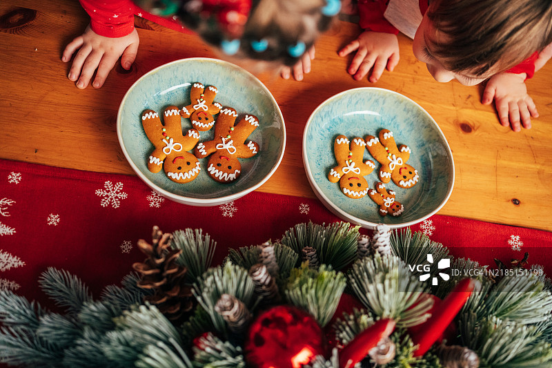 带着人工耳蜗的女孩在家与家人一起享用姜饼，庆祝圣诞节。图片素材