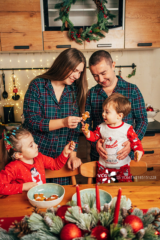 带着人工耳蜗的女孩在家与家人一起享用姜饼，庆祝圣诞节。图片素材