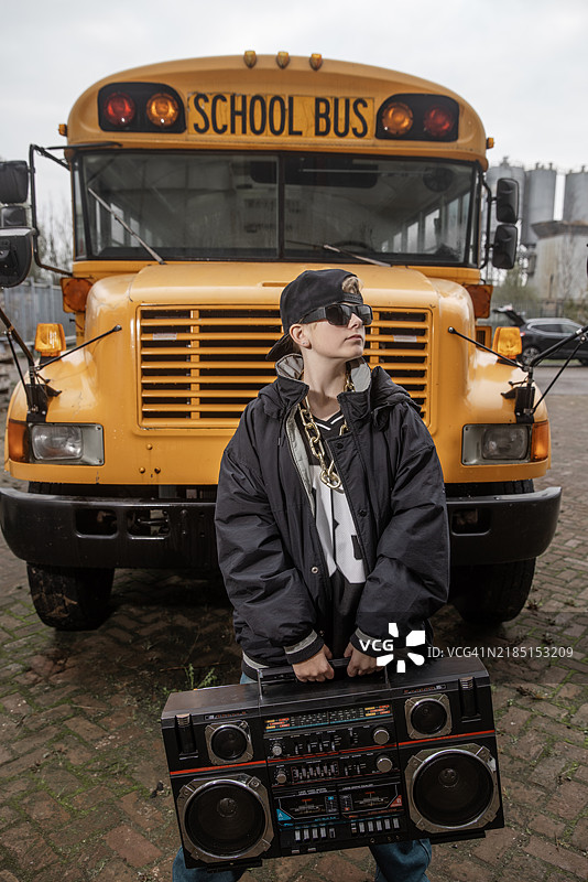 一幅美丽女孩的肖像，代表1980年代的嘻哈文化，背景是一辆校车。图片素材