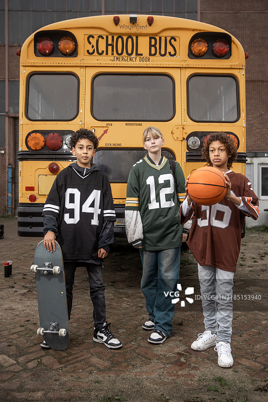 三名混血儿童代表1980年代嘻哈文化，身旁有一辆校车图片素材