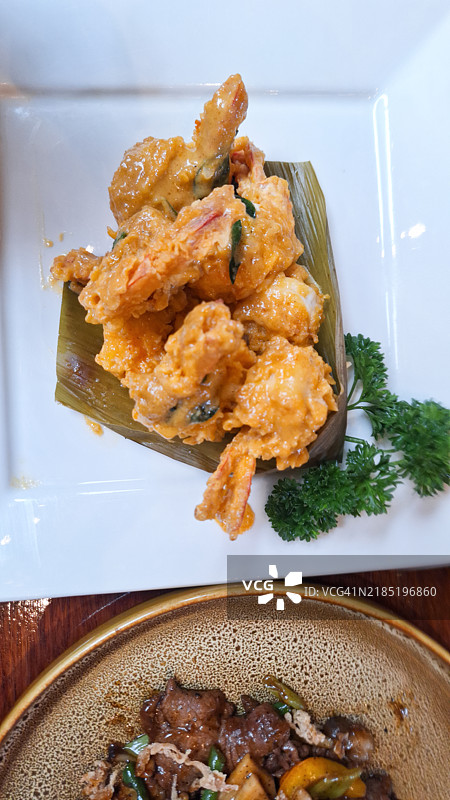 白盘上的虾仁配咸蛋黄酱的平铺展示图片素材