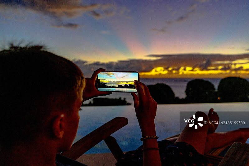 可爱男孩在泳池边拍摄日落图片素材