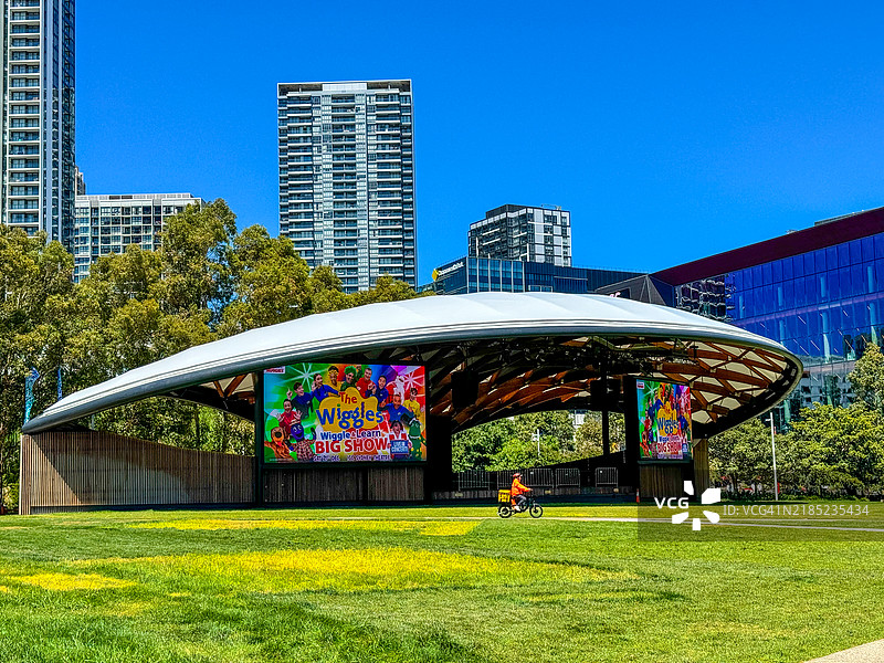 在悉尼的坦巴隆公园，送货员骑自行车经过音响壳。图片素材