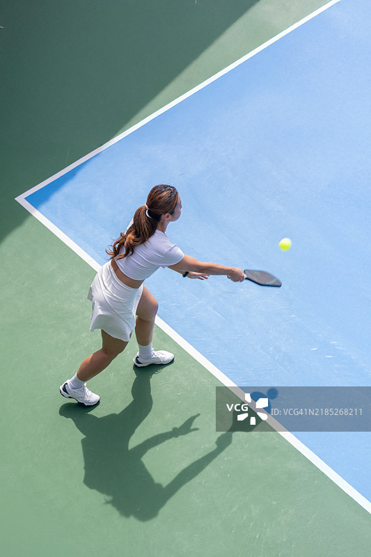 运动中的游戏：一名皮克尔球运动员的户外发球图片素材