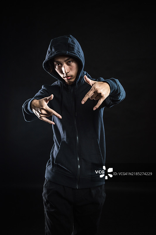 年轻帅气的男子在户外穿着连帽衫图片素材