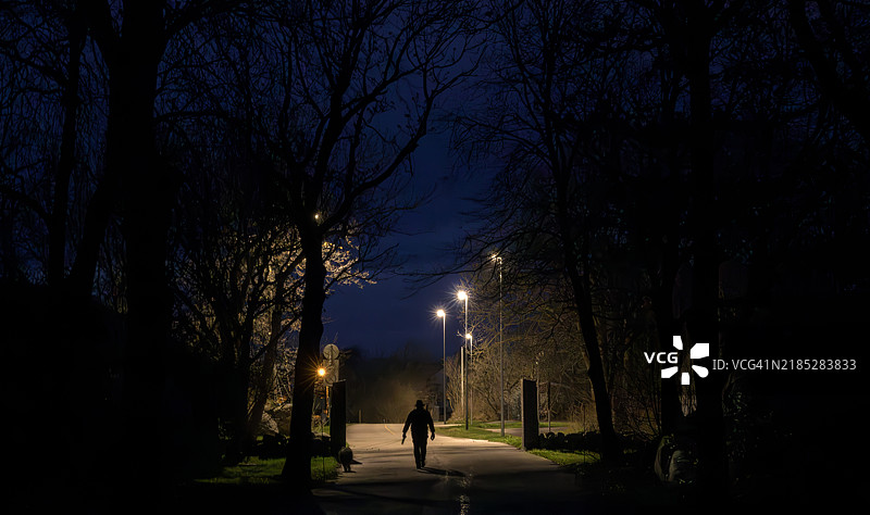 走出黑暗的公园，走向街灯下图片素材