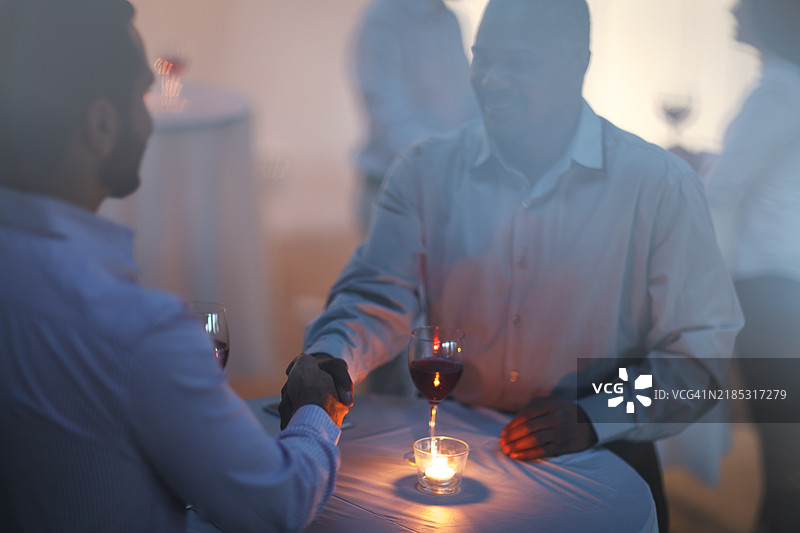 黑人成熟男性与中东中年男性在多元文化的接待派对上握手交流图片素材