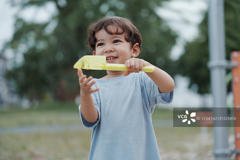 可爱的亚洲男孩在阳光明媚的日子里玩耍，享受游乐场的乐趣。户外活动。图片素材