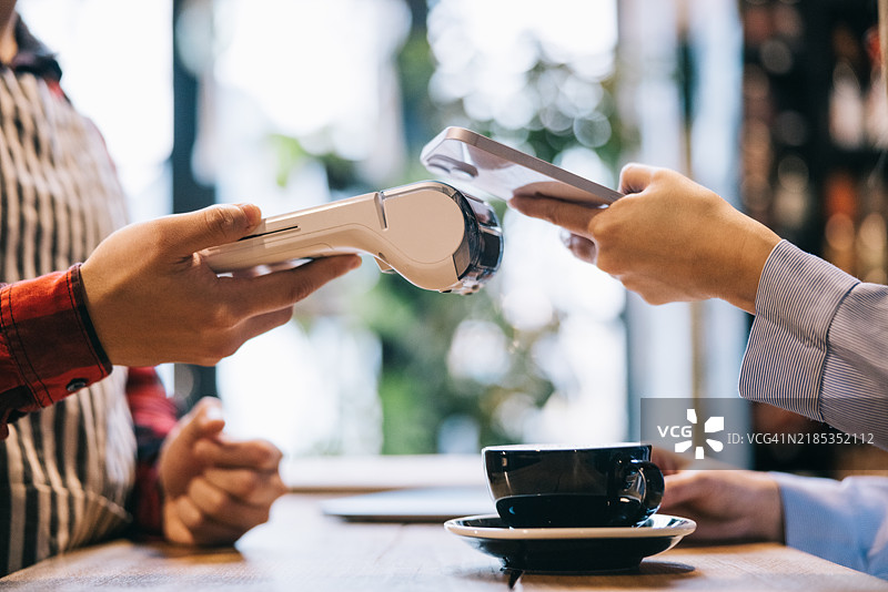 在咖啡馆用手机支付图片素材