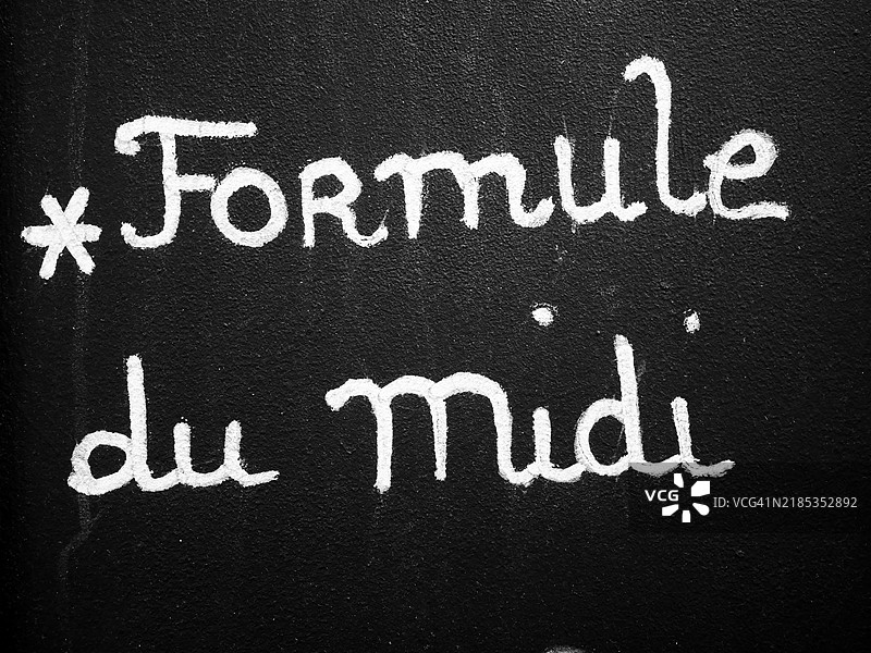 法国餐厅黑板上手写的“午餐套餐”。“午餐套餐”是餐厅提供的午餐组合，包括1道开胃菜、1道主菜和1杯饮料。阳光。黑白色。巴黎，法国。图片素材