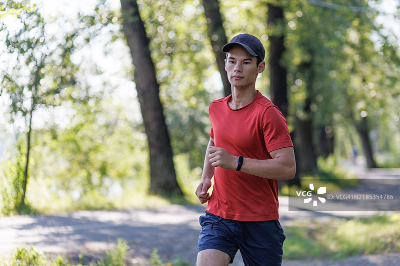 年轻男子在公园小径上奔跑图片素材