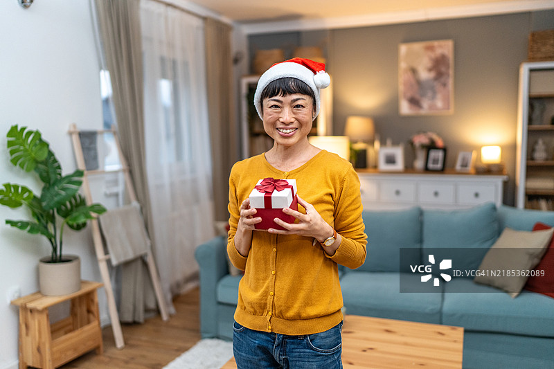 戴着圣诞帽的日本女性手持圣诞礼物图片素材
