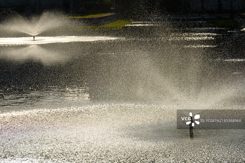 背光的池塘喷泉图片素材