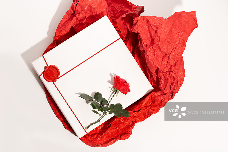 情人节和妇女节贺卡，配有红玫瑰、白色礼品盒和红色包装纸，背景为白色。图片素材