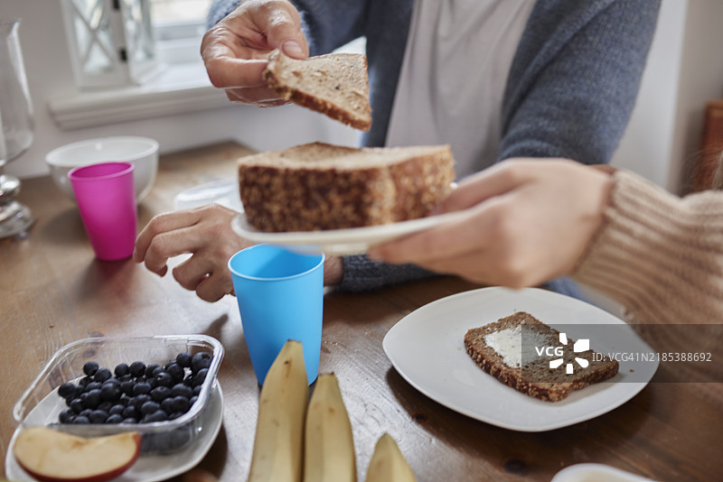 女孩在家里把装有面包的盘子递给父亲图片素材