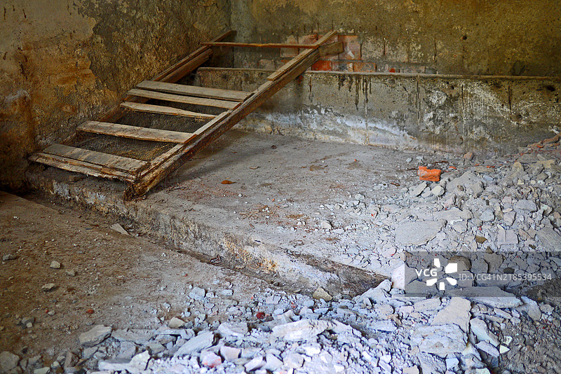废弃的马厩，污迹斑斑的墙壁，石槽，破损的梯子，杂物图片素材