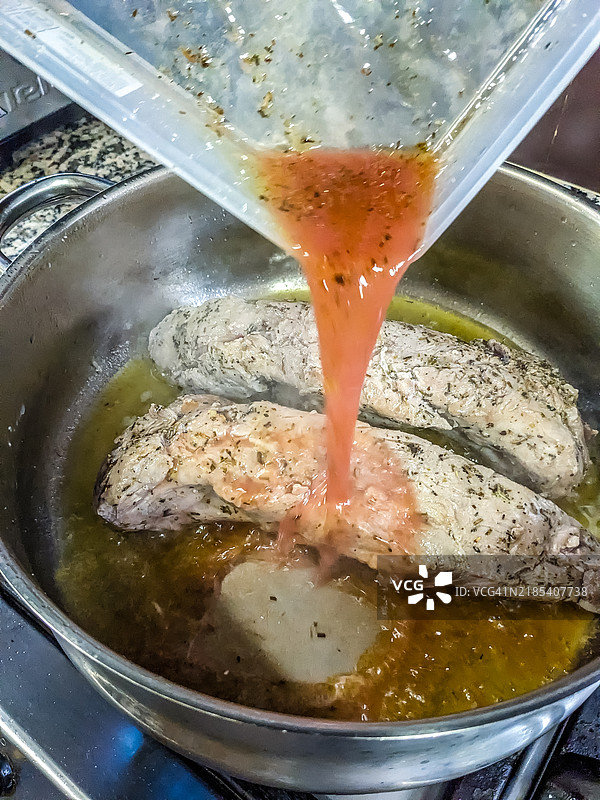 在平底锅中为西冷牛排添加肉汁图片素材