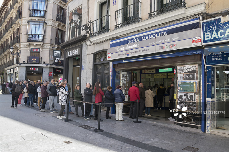 马德里著名的多娜·马诺利塔彩票店外排队的人群，这是一个标志性的地标。图片素材