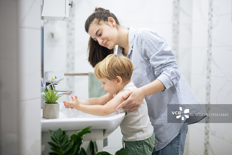 妈妈在浴室里帮我洗手。图片素材