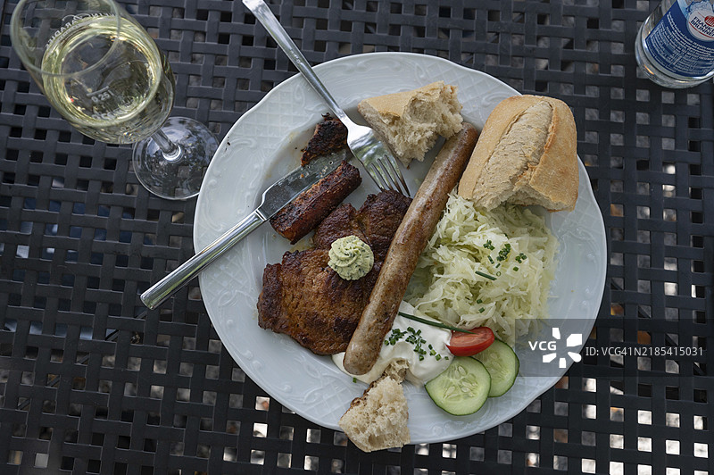 在德国巴伐利亚的一家花园酒吧里，牛排和香肠配上卷心菜沙拉和奶酪。图片素材