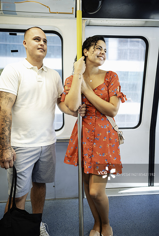 年轻的拉丁裔情侣乘坐公共交通地铁或轻轨图片素材