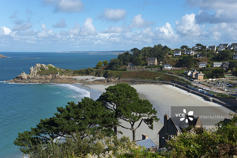 蓝天下，树木和房屋环绕的沙滩海岸风景，特雷斯蒂涅尔沙滩，佩罗斯-吉雷克，阿摩尔海岸，布列塔尼，法国，欧洲图片素材