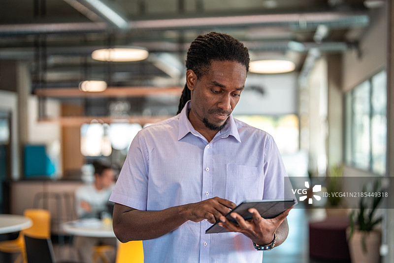 西班牙裔商人在共享办公空间使用平板电脑图片素材