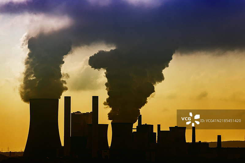 日落时分的德国尼德奥斯姆大型燃煤电厂，冒着烟的烟囱图片素材