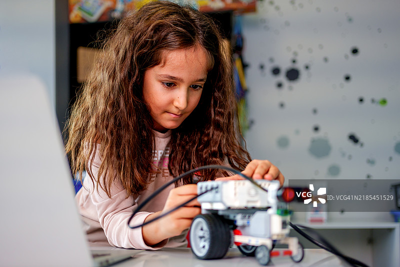 一名女学生参与动手的机器人和STEM教育活动图片素材