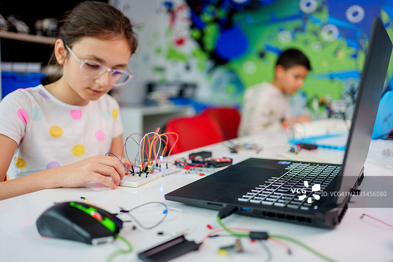 一名女学生参与动手机器人和STEM教育活动。图片素材