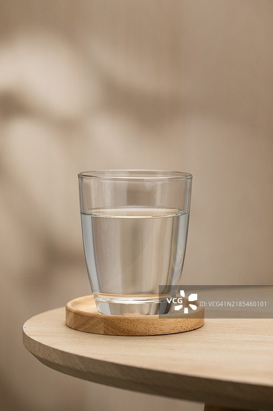 一杯清澈的饮用水放在木桌上图片素材