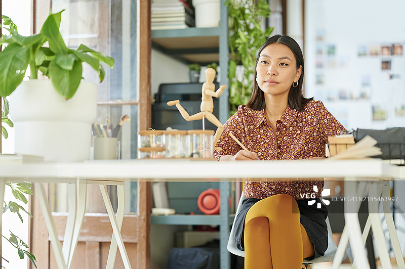 女人在画画，注视着玩偶图片素材