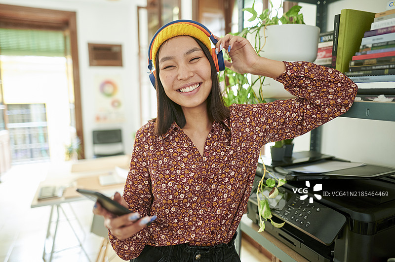 办公室里戴着耳机听音乐的女性图片素材