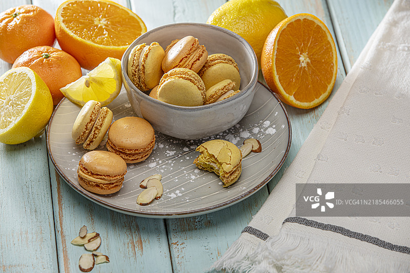 橙子和柠檬马卡龙饼干，甜点放在复古木背景上图片素材