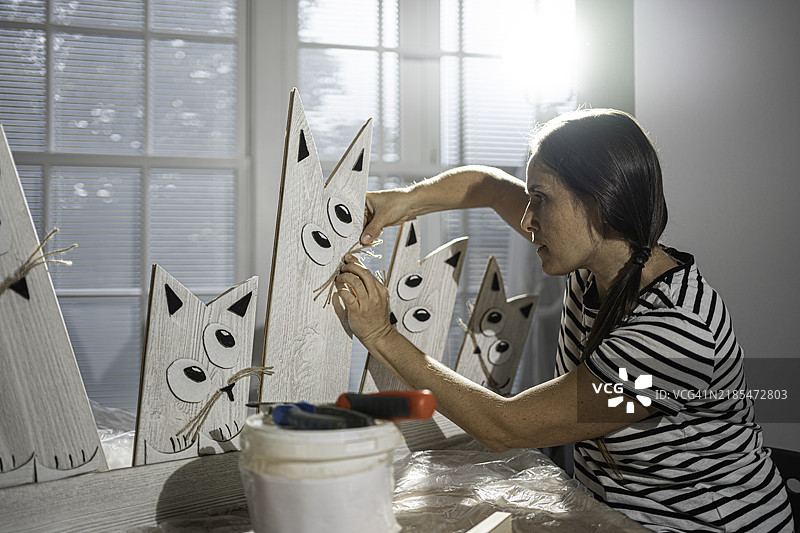 木匠在工作室里制作工艺品，猫雕塑图片素材