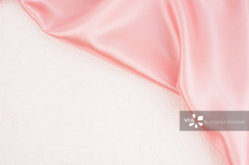 粉色丝绸织物与粉色皱纸背景，留有空白位置。图片素材
