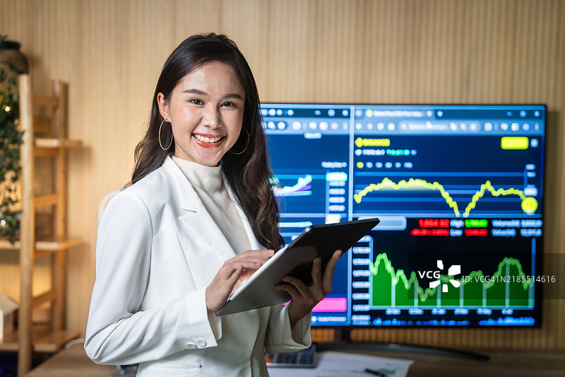 女商人在数字平板上分析股市数据图片素材