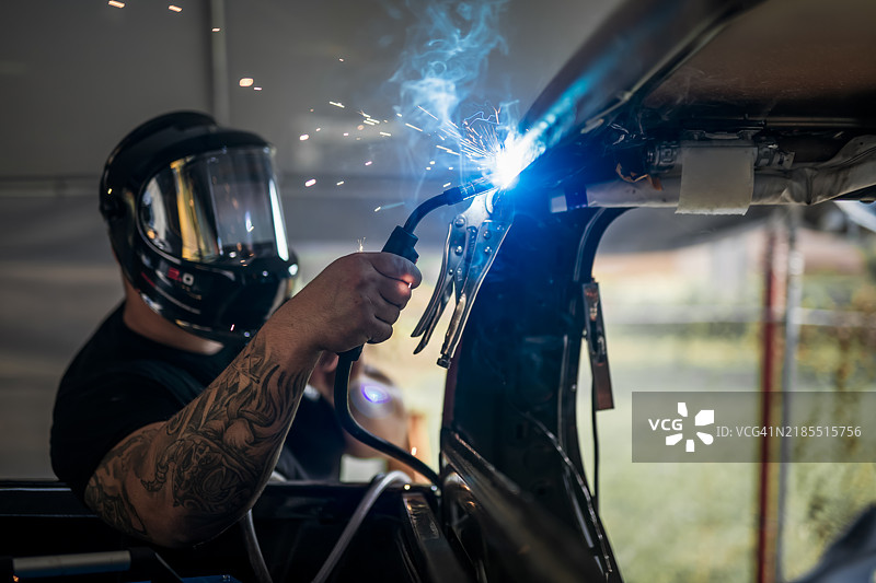 焊工在车间修理汽车。图片素材