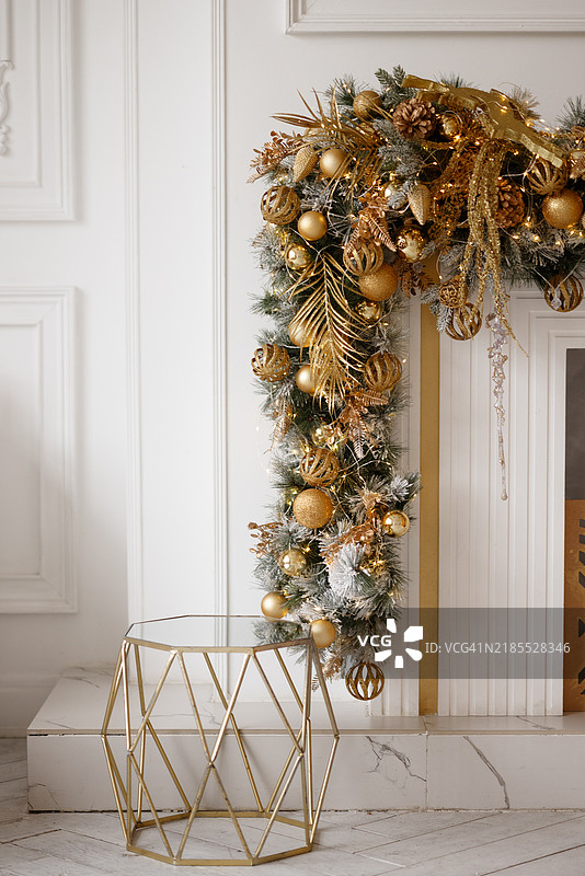 一棵金色和白色的圣诞树，配有金色和白色的壁炉台。图片素材