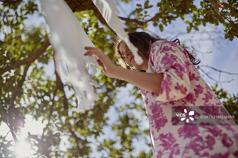 低角度视图的女性在晾晒衣物图片素材