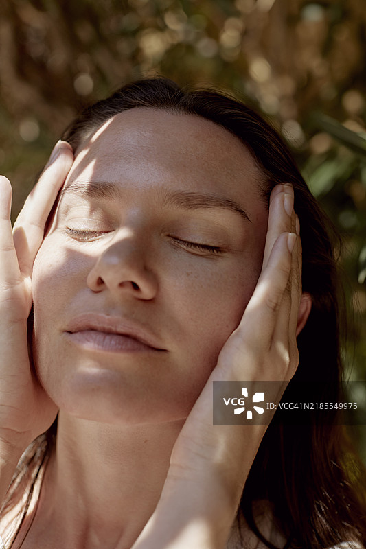 闭眼触摸太阳穴的美丽女性特写图片素材