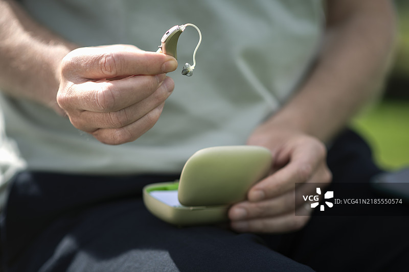 男子手持助听器的特写镜头图片素材