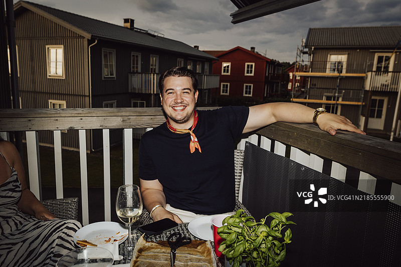 黄昏时分，英俊年轻男子坐在阳台上。图片素材