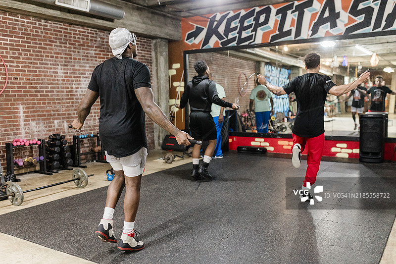 拳击手在健身房镜子前练习跳绳训练图片素材
