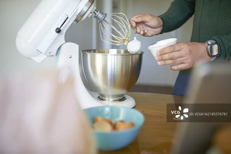 男子将酸奶加入自制蛋糕面糊中图片素材