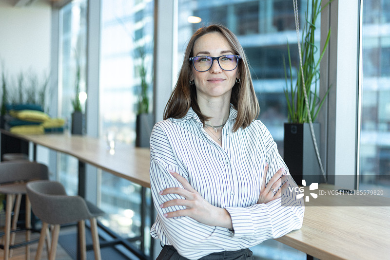 自信的女商人在现代办公室环境中站立图片素材