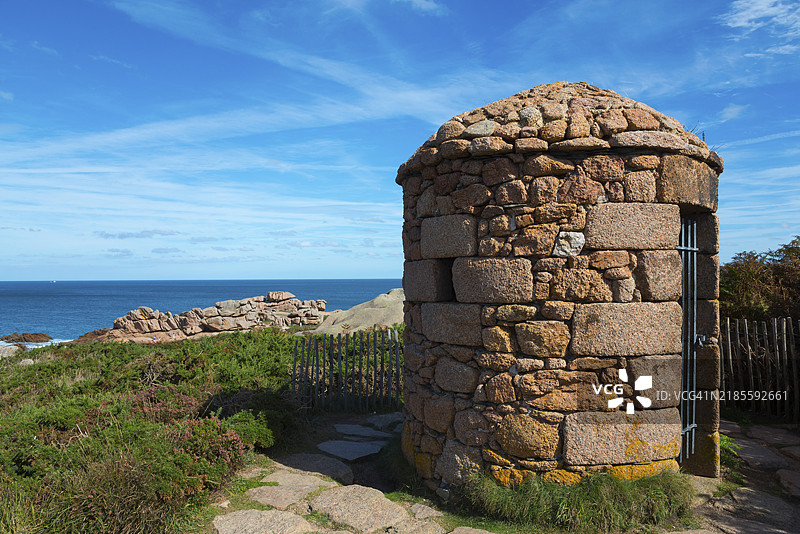 海边岩石上的小石屋，俯瞰着海洋和蓝天，海关小屋，布列塔尼海关小道，普洛曼纳赫，佩罗斯-吉雷克，阿摩尔海岸，布列塔尼，法国，欧洲图片素材